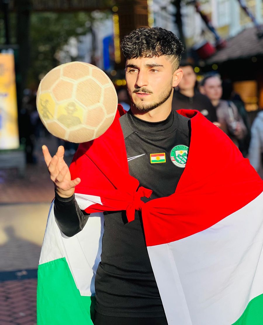 Kurdischer Freestyler in die Flagge gehüllt, Ball in der Hand